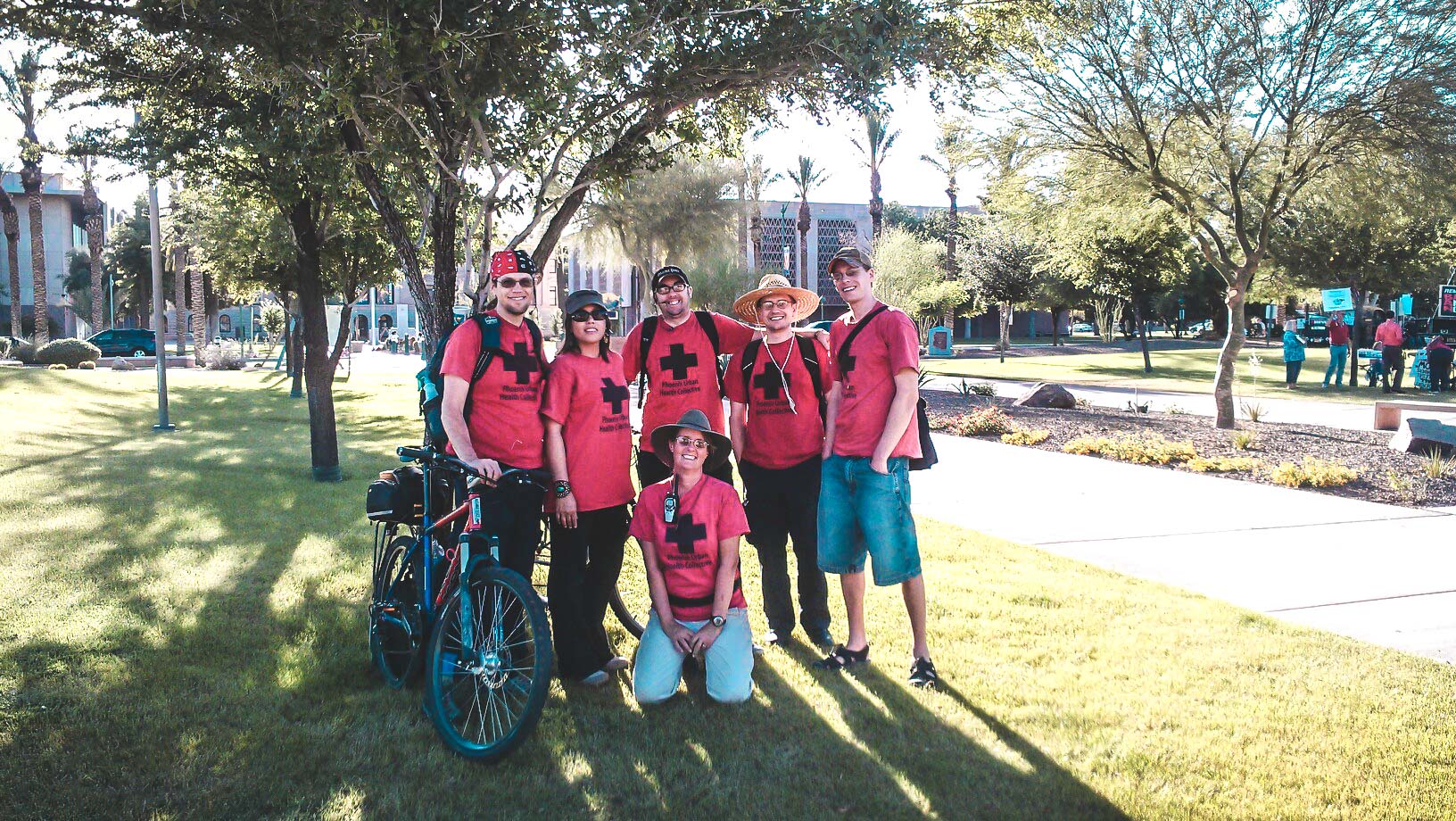 PACH street medic volunteers in red shirts posing together outdoors at a protest.
